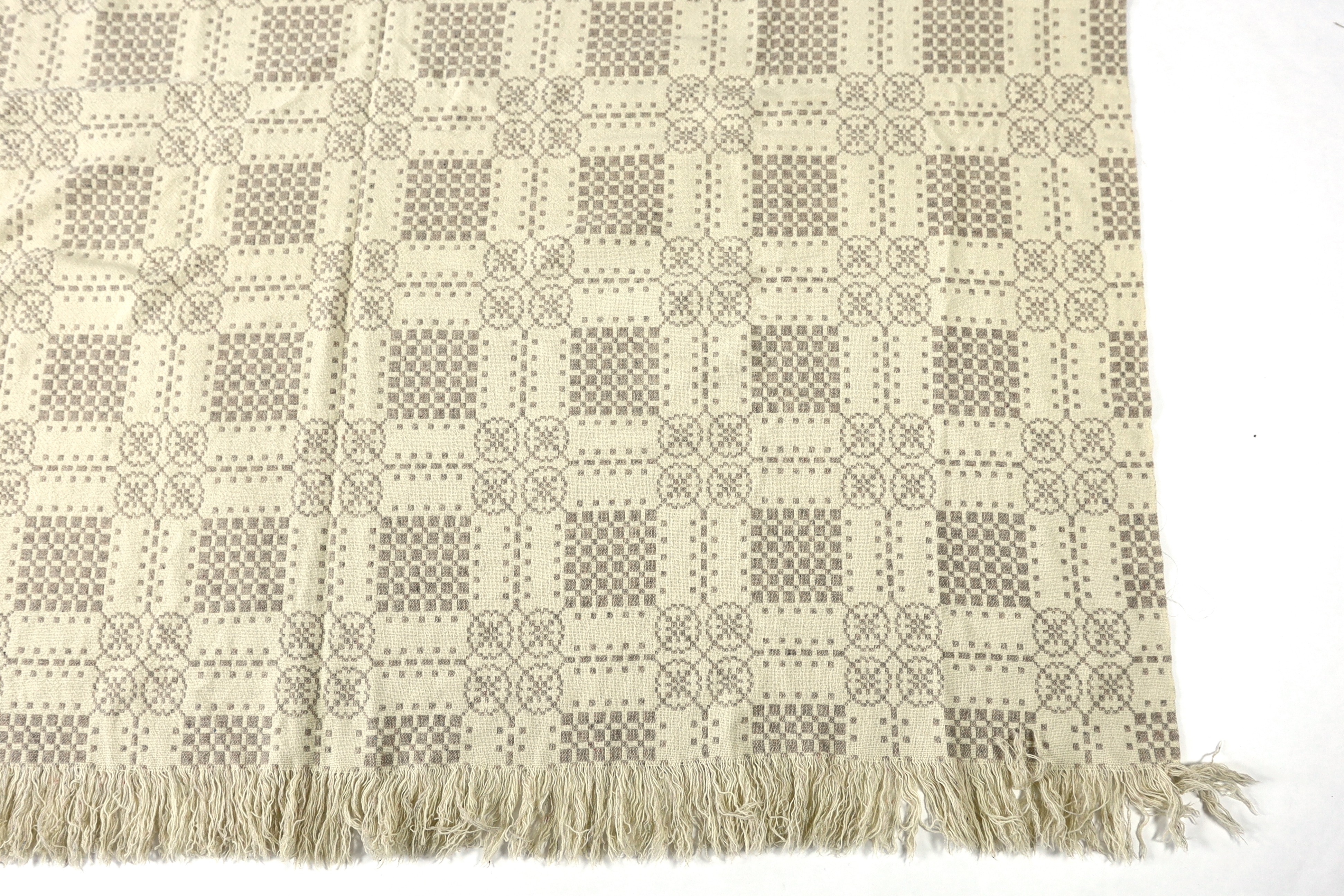 A Welsh wool woven blanket, using mushroom and cream wool in a reversible geometric design, 192cm wide x 212cm long